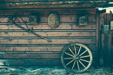 Obraz premium Old peasant tools hanging on wooden wall on animal farm.