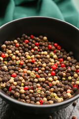 Bowl with mixed peppercorns on table, closeup