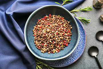 Bowl with mixed peppercorns on dark background