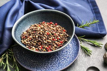 Bowl with mixed peppercorns on dark background