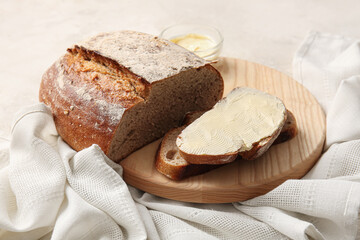 Fresh bread with butter on light background