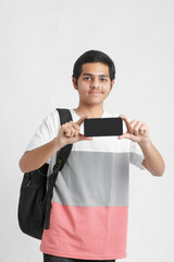 Young indian college student showing smartphone screen on white background.