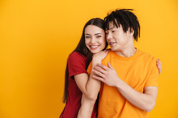 Young multiracial couple smiling and hugging while posing on camera