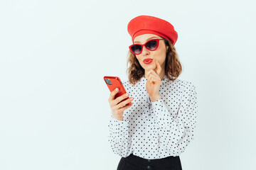 Fashionable elegant young woman wearing red beret, sunglasses and polka dot blouse