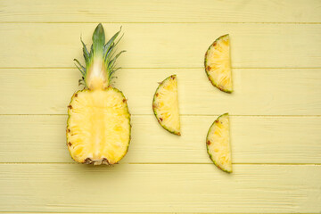Cut fresh pineapple on color wooden background