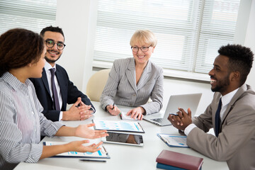 Group of multi-ethnic business people sitting around the office desk and discussing the project