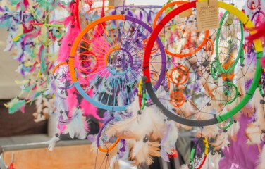 Naklejka premium Atrapasueños coloridos en un mercado callejero para la venta. Objetos colgados en los puestos expuestos para la venta en el rastro de Madrid, España.