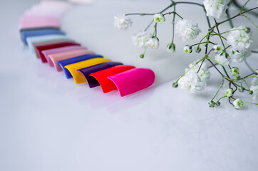 Samples of summer shades of gel polish for manicure. Nail testers on a white background with...