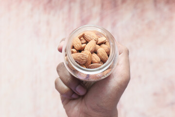 top view of almond nuts on man's hand 
