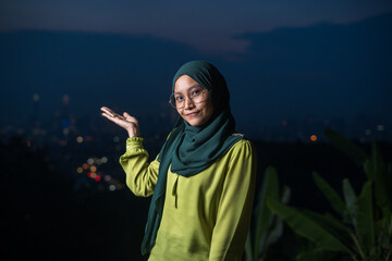 Portrait of young Asian woman during sunset, blue hour at hill view point, Bukit Ampang near Kuala Lumpur. Blurred background