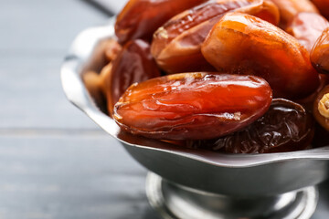 Bowl with sweet dried dates on table, closeup