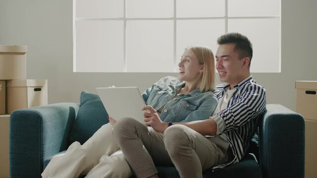 Cheerful lady and smiling man hold tablet surfing internet