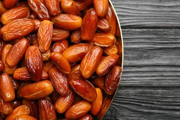 Plate with sweet dried dates on dark wooden background, closeup