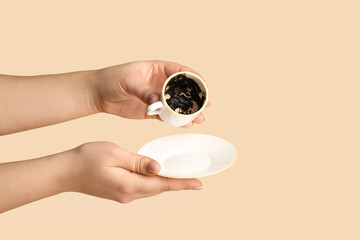 Woman reading coffee grounds on color background