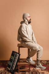 Fototapeta premium Full-length portrait of man, musician isolated on light yellow background.
