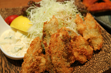 Closeup Japanese Dish of Deep Fried Oysters or Kaki Furai Topped with Tartar Sauce and Shredded Cabbage