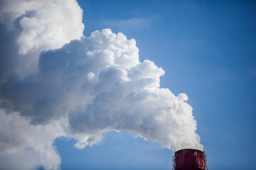 steam smoke from an industrial red-white pipe