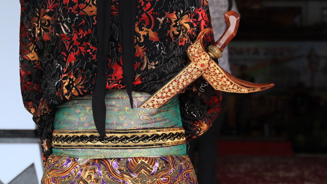 Men wearing traditional Javanese attire with keris. Keris is a traditional Javanese weapon. With black background
