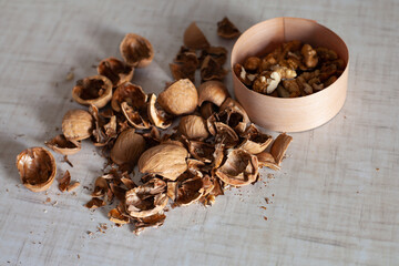 large horizontal photo. Walnut. Peeled walnut shell. Dry shell. Harvest of nuts. White table. Vitamins. Healthy eating. ECO.