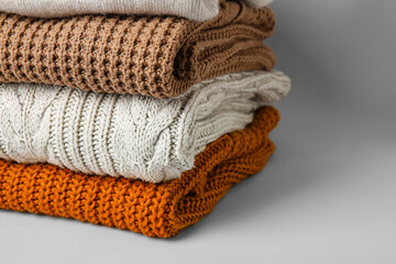 Stack of stylish clothes on grey background