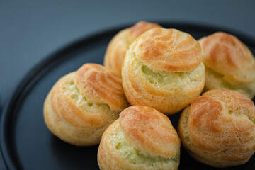 mini pandan custard choux cream on black plate