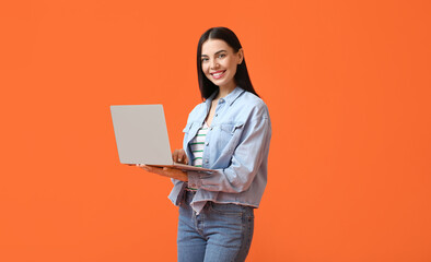 Young woman with laptop on color background