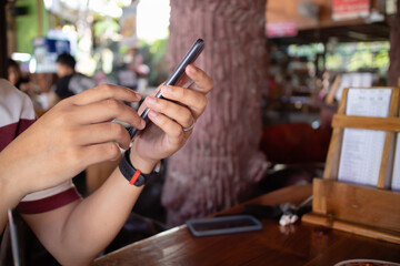 person using smartphone in cafe