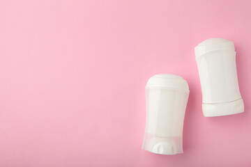 White antiperspirant deodorant on pink background. Skin care concept. copy space, top view