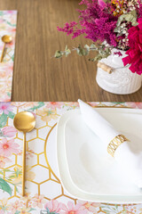 Plate and utensils, on the table decorated with a small flower arrangement