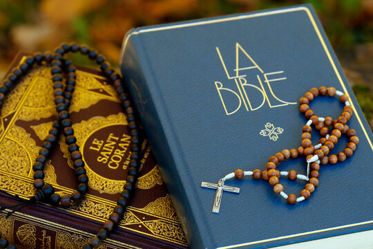 Holy Quran in French with Muslim prayer beads and Bible with rosary, Interfaith symbols between Christianity and Islam, France