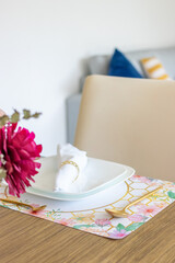 Plate and utensils, on the table decorated with a small flower arrangement