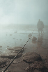 Obraz premium People walking through the cloud of steam from the erupted geyser. 