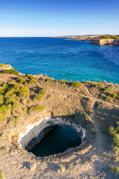 Natural stone arch and open grotto framed by turquoise sea, Otranto, Lecce province, Salento, Apulia, Italy