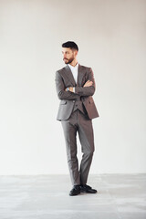 Posing for a camera against white background. Young stylish businessman in suit indoors