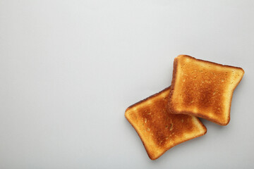 Slices of toast bread on grey background with copy space