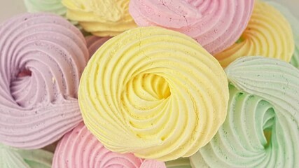 Close-up delicious meringue cookies pastel colors rotating. French pastries, sweet crunchy swirls candy, multicolored marshmallows. A whipped fluffy vanilla dessert made with egg cream and sugar. - Powered by Adobe