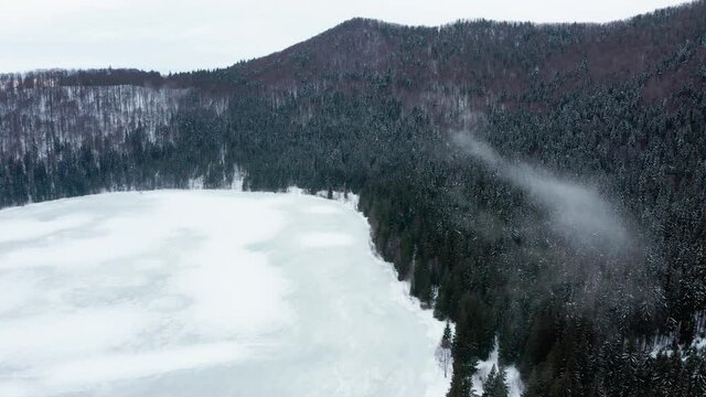 Frozen volcanic Saint Ann or Sfanta Ana lake crater, Romania. Aerial rising