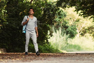 Young latin man walking in the forest