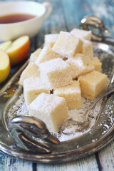 Apple gelatin dessert. Sugar free. Homemade marshmallow cubes in coconut flakes and cup of tea