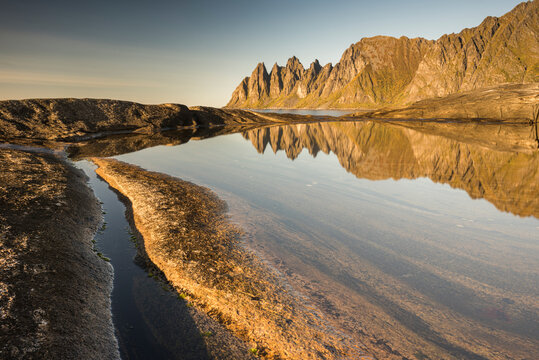Reflection in rock pool of Devil's Teeth Mountains, from Tungenet, evening sunlight, Senja, Norway, Scandinavia