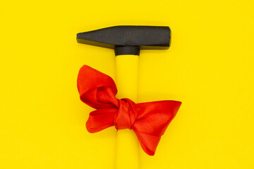 International Workers' Solidarity Day, 1 May concept, a yellow hammer with red ribbon on a yellow...