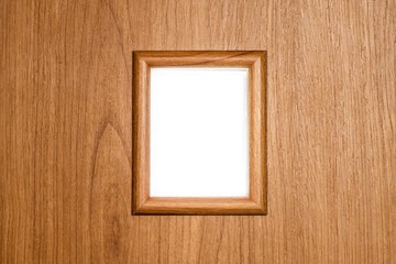 Textured small decorative window in a frame on a wooden wall with a white background behind.