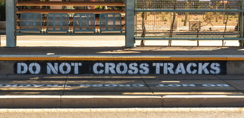 do not cross tracks painted on the tracks and curb at a light rail station