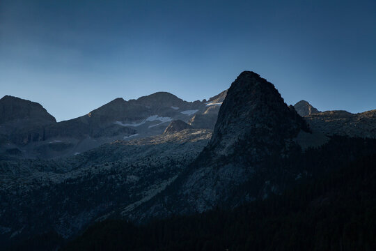 First light of dawn over the solitary mountains in summer, under a clean and huge blue sky, Aragonese Pyrenees, provincia de Huesca, Posets-Maladeta Natural Park.