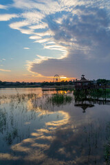 Wonderful sunset with unusual clouds at lake and City Park in Rishon Le Zion. Warm autumn evening. Natural landscape. Israel