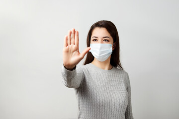 Young woman wearing medical mask, white background.