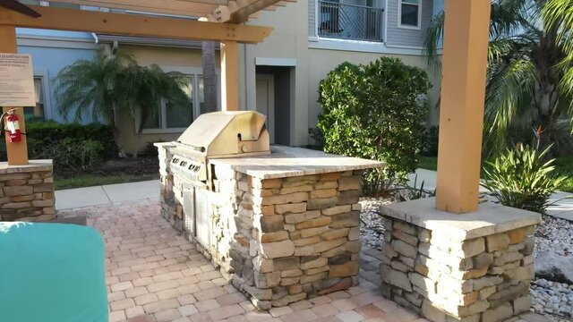 zoom in view of grill under and arbor trellis in a community cooking area