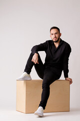 Portrait of a guy sitting in a wooden box