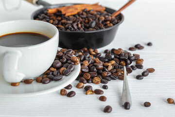 coffee cup and coffee bean on white wooden table