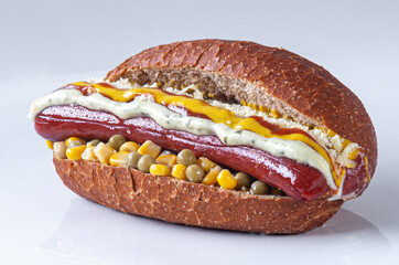 Special hot dog, sandwich served with sausage, green corn, peas and sauces on whole grain breadsauces on special bread